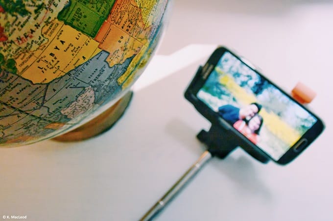 Globe and selfie stick on white surface