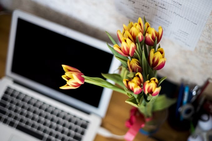 Flowers and a laptop on a desk
